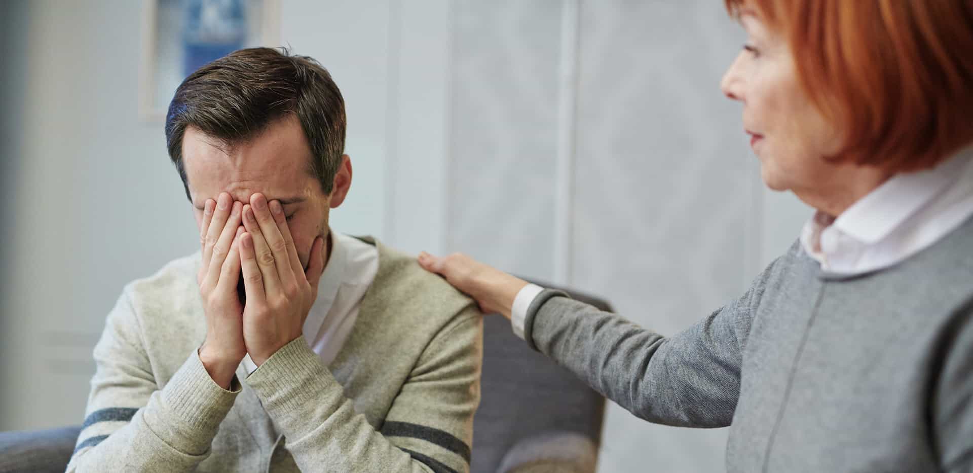 Emotional support in therapy session with a therapist comforting a client.