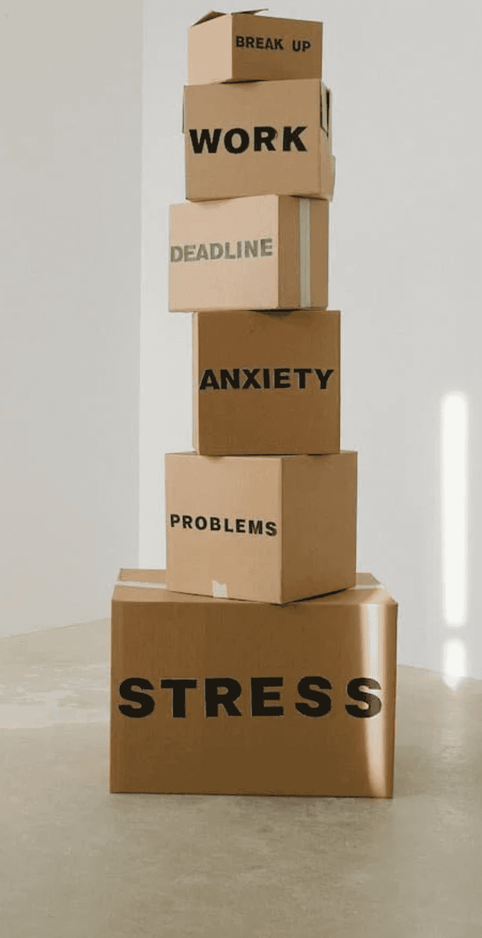 Stack of boxes labeled with stress-related words for life transition therapy.
